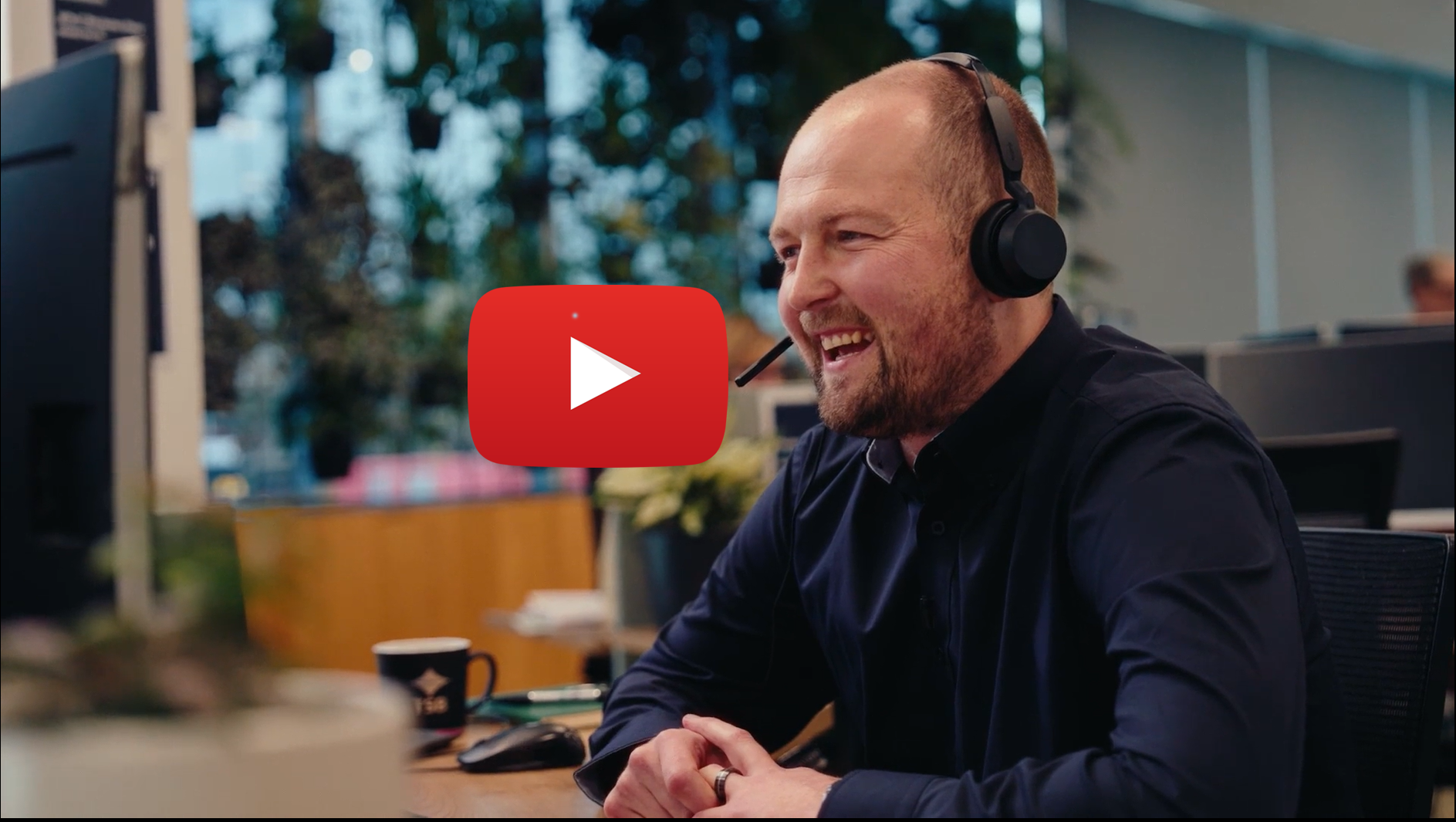 TSB team member wearing a headset at an office desk