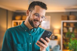 Man smiling at phone applying for Chubb insurance on his mobile