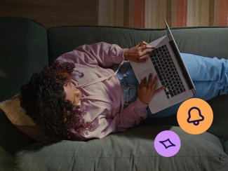 Woman sitting on a couch with her laptop applying for a TSB credit card