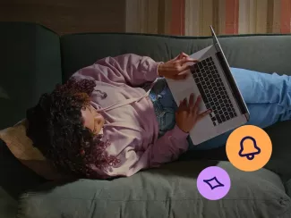 Woman sitting on a couch with her laptop applying for a TSB credit card