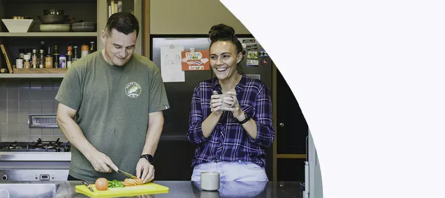 couple at kitchen bench cooking dinner and talking