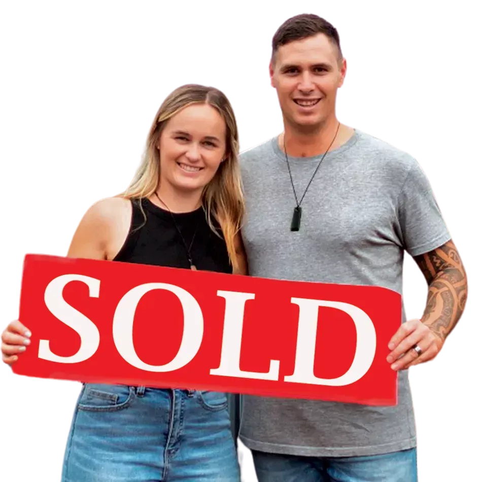 Couple holding a sold sign