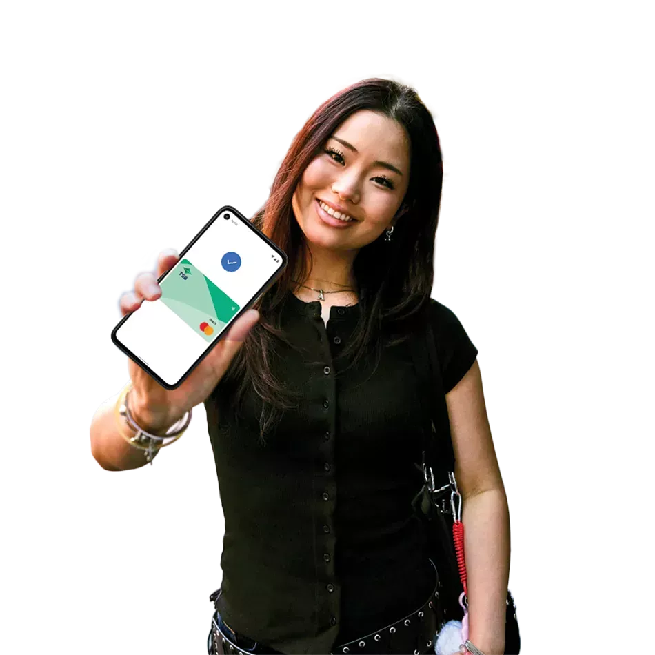 Happy young woman holding her cell phone in the street