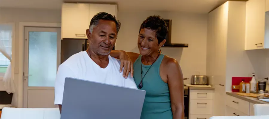 Man & woman in the kitchen look at their finances