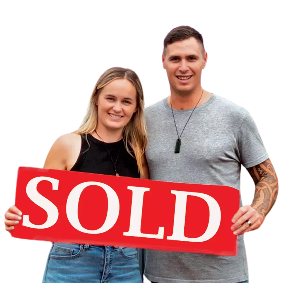 Couple holding a sold sign