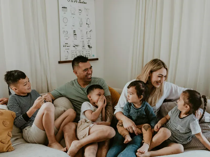 Family of 6 sitting on the couch laughing