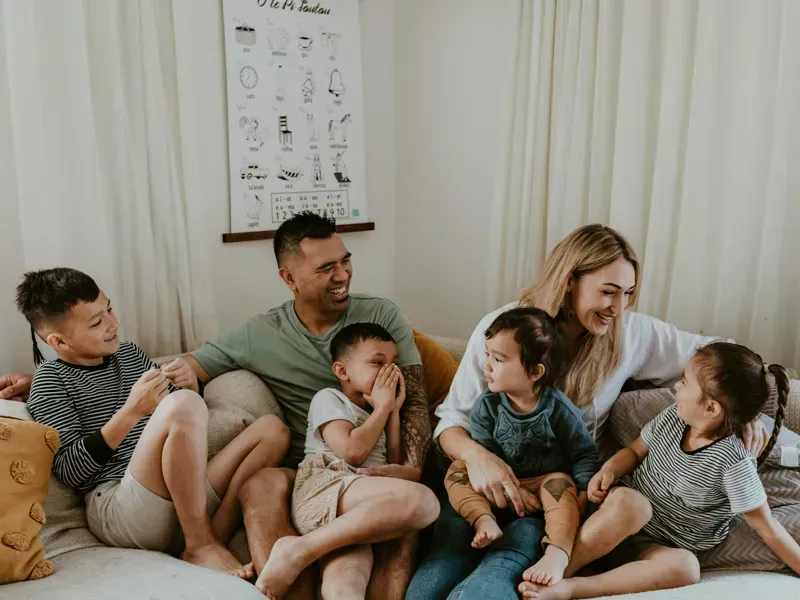 Family of 6 sitting on the couch laughing