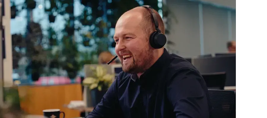 TSB team member wearing a headset at an office desk