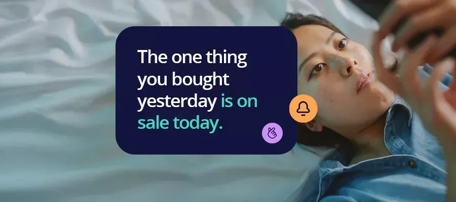 Woman lying on her back on a bed looking at her phone