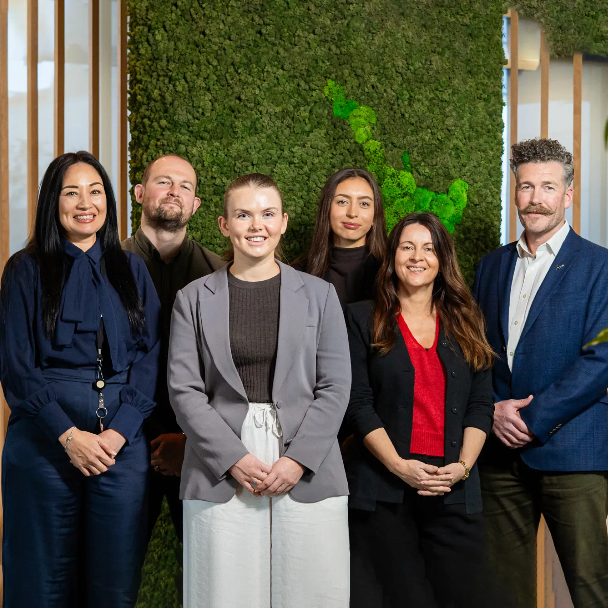 Group of TSB team members standing together in an office setting
